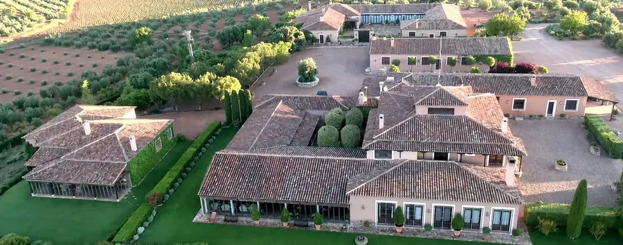 Aerial view of the lodge complex at El Crespo, tiled roofs and gravel courtyards among olive groves