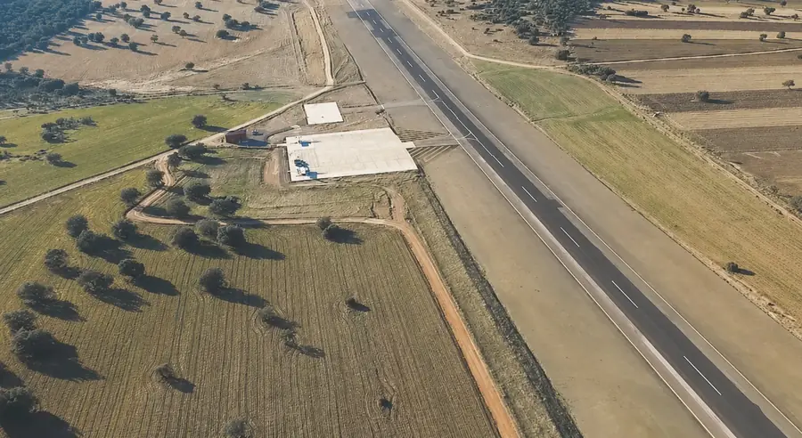 The private asphalt airstrip at La Nava seen from the air, beside farmland and oak pasture