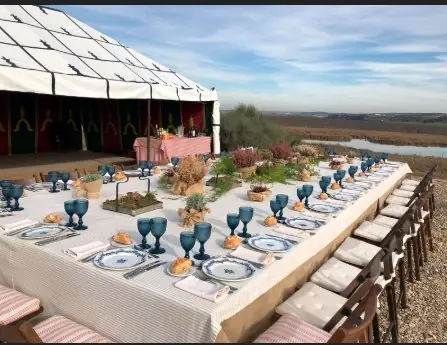 A table laid under a striped campaign marquee at Ventosilla, looking out over the river